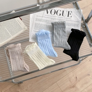 Detail of sweet ruffle cuffs and diamond mesh texture on five colors of mid-calf socks