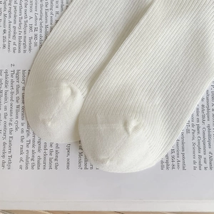 Close-up of seamless toe stitching and ribbed texture on white cotton crew socks