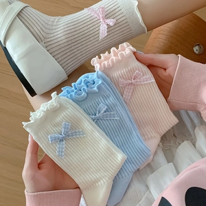 Detail of sweet ruffle trim socks with bows in white, blue, and pink pastel colors