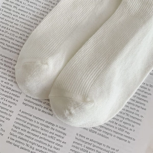 Macro shot of white lace socks showing fine vertical ribbing and seamless toe stitching