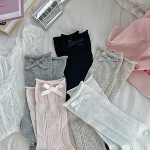 Flat lay of sweet style mesh socks featuring ribbons, bows, and heart cutout patterns