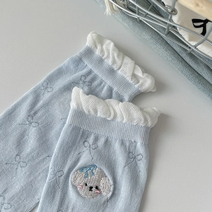 Close-up of light blue cotton socks featuring white lace trim and cute puppy embroidery