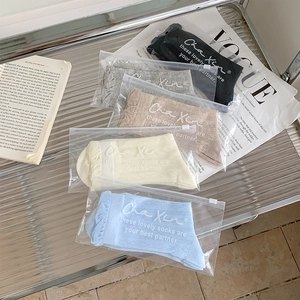 Close-up of five pairs of ballet style mesh socks with frilly cuffs in zip bags