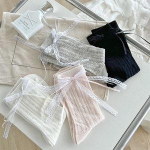 Dettagli di quattro paia di calzini con pizzo e fiocchi in grigio nero beige e rosa