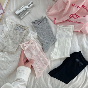 Close-up of five pairs of hollow mesh socks with delicate bows in multiple colors