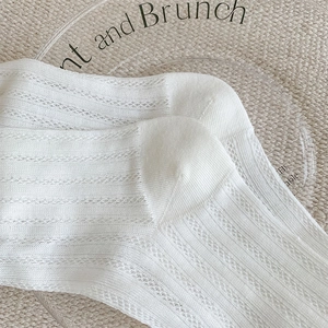 Detailed close-up of white mesh socks showing breathable hollow knit and ruffled edge