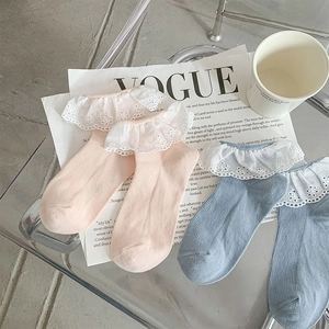 Detailed view of pastel pink and blue ribbed socks with delicate white lace trim