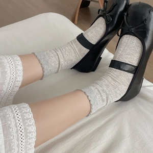 Detail of crochet floral pattern on light grey crew socks with wavy lace cuffs