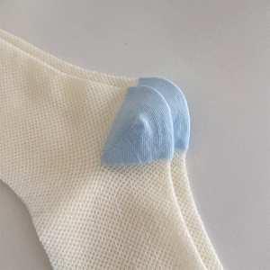 Detailed macro view of white mesh socks featuring a light blue reinforced heel and fine stitching