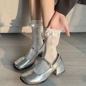 Détail de chaussures Mary Jane argentées portées avec des chaussettes blanches à volants