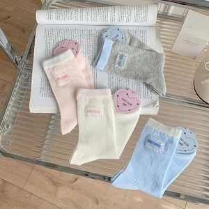 Detail of pink and white lace-label socks with ribbed knit texture and KIKI SOX embroidery