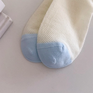 Close-up of breathable cotton mesh socks with blue toe stitching and refined texture