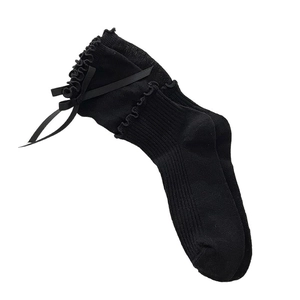 Black double-layered ruffle socks with silk bows in a sweet Lolita style flat lay