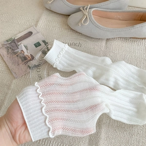 Close-up of white mesh socks showing elastic ruffled edges and breathable knit texture