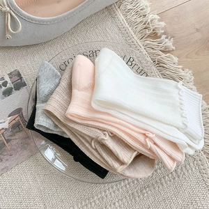 Close-up of ruffled cuff socks in assorted pastel colors with fine vertical knit texture