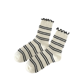 Cream crew socks with black stripes, ruffle cuffs and breathable mesh heart pattern