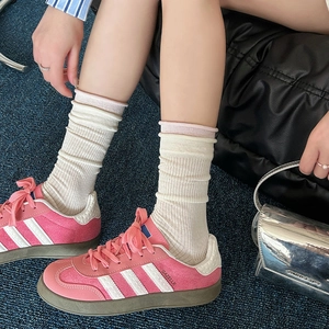 Sneaker in pelle scamosciata rosa con strisce bianche e calze a coste color avorio