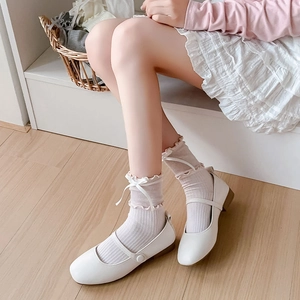 Close-up of white mesh crew socks with ribbon bow and elegant frill lace trim
