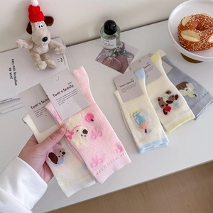 Detail of assorted pastel cotton socks featuring cute cartoon animal embroidery and ribbon trim