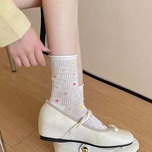 Detail of white mesh socks with colorful polka dots and sweet ruffled edges