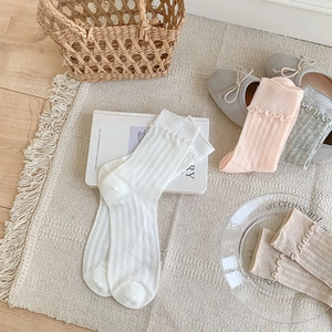 Detail of sweet ruffle cuffs and vertical ribbed knit texture on assorted color socks