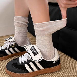 Macro detail of the breathable waffle knit texture and high elastic cuff on beige socks