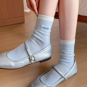 Light blue ribbed crew socks with white trim and embroidery paired with Mary Jane shoes