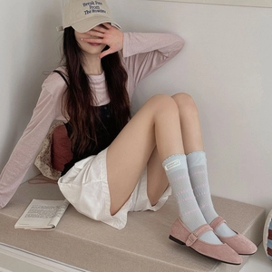 Close-up of light blue lace trim crew socks paired with pink velvet Mary Jane shoes
