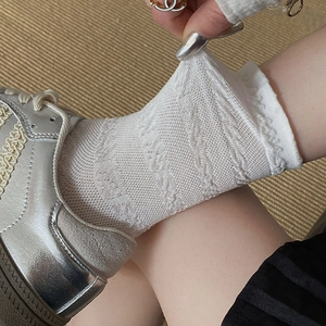 Détail macro de chaussettes blanches en coton ajouré avec dentelle élastique et motifs fleuris