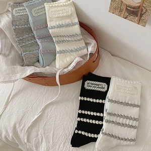 Detail of knit socks with horizontal stripes and chic wavy lace label in various colors