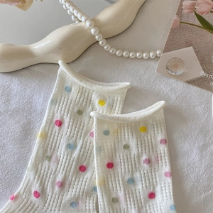 Detail of white mesh socks with colorful polka dots and lettuce trim edges