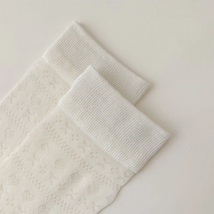 Detail of white mesh socks with heart-shaped cutouts and ribbed elastic cuffs
