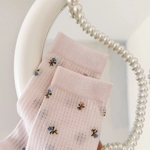 Gros plan de chaussettes roses avec motifs floraux et maille respirante détaillée