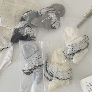 Détail de chaussettes à froufrous en dentelle avec emballage individuel style lolita