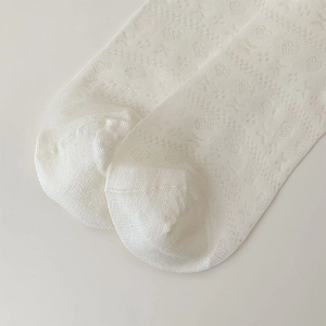 Detailed close-up of breathable white mesh socks with heart patterns and seamless toe stitching