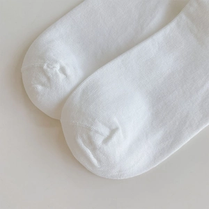Detail shot of white ribbed knit fabric and reinforced toe stitching on summer socks