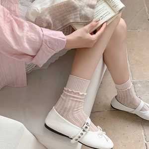Detail of ruffle trim socks with vertical ribbed knit and delicate wavy edges