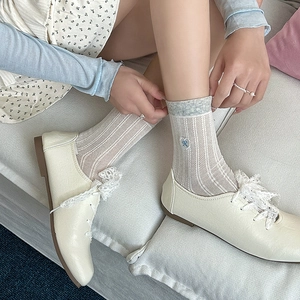 Detail of white hollow-out mesh socks with blue heart bow embroidery and lace-up shoes