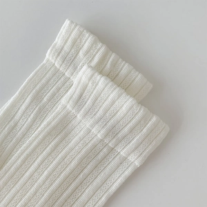 Close-up of white mesh ribbed cotton socks showing the elastic cuff detail and knit texture
