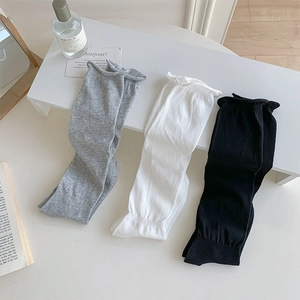 Detailed view of rolled cuff knit socks in black, white and grey on a clean display