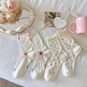 Detail of breathable white mesh crew socks with colorful polka dots and pink ruffle trim