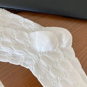 Gros plan détaillé de chaussettes mi-mollet blanches en coton avec motif en dentelle ajourée
