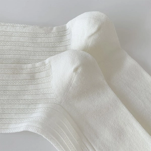 Detailed macro view of white ribbed knit socks with breathable mesh texture and fabric details