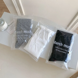 Detailed view of grey white and black cotton socks in minimalist frosted packaging