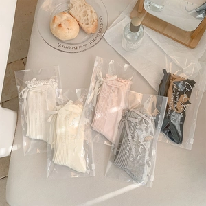 Detail of ballet style ribbons and bow ties on ribbed cotton socks in gift packaging