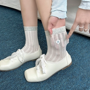 White mesh socks with bow embroidery and vertical stripes shown on feet with shoes