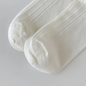 Close-up of white vertical ribbed knit mesh socks showing seamless toe detail
