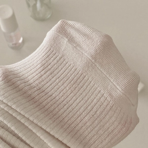 Détail macro de la texture en maille côtelée crème et couture sans couture sur la pointe