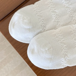 Gros plan de chaussettes blanches en maille avec mesh respirant et texture jacquard