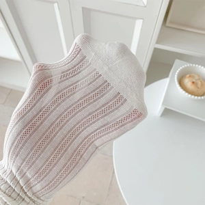 Detail of white mesh socks showing vertical stripes and elegant ruffled edges